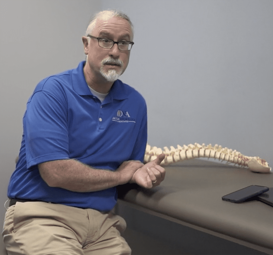 a man sitting on a desk with a skeleton of a human